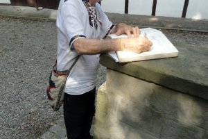 Irlandzki ksiądz Patrick Clark wpisujący się w imieniu Brazylijczyków do księgi pamiątkowej muzeum
